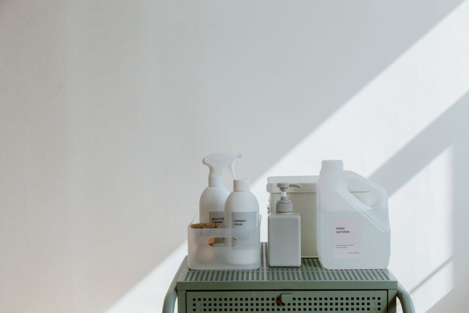 Aesthetic arrangement of cleaning products in minimalistic containers with soft shadow play.